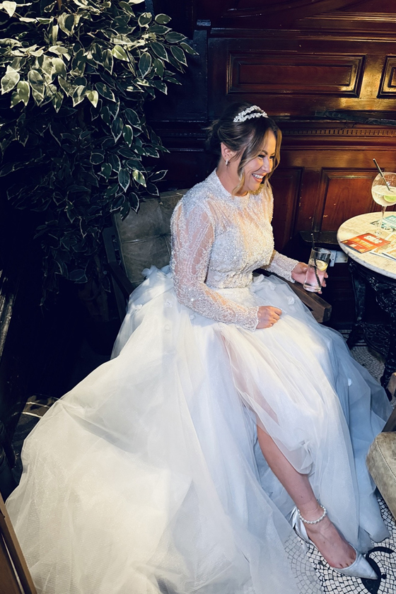 Bride smiles as she sits at table, captured by wedding content creator in Scotland Unveiled Moments